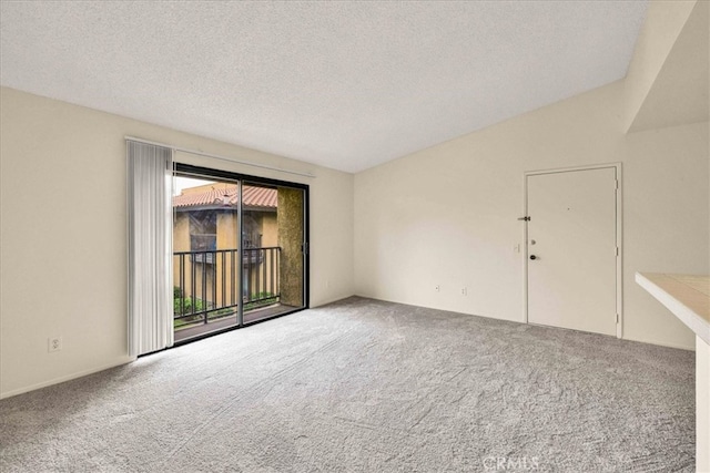 spare room featuring lofted ceiling, a textured ceiling, and carpet flooring