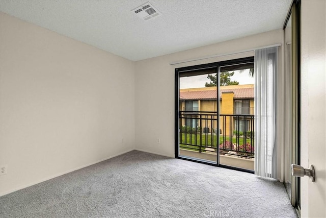 carpeted spare room with a textured ceiling and visible vents