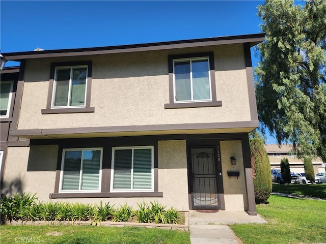 view of front of house featuring a front yard and stucco siding