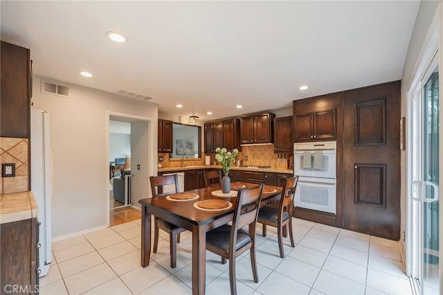 dining area with light tile patterned floors, visible vents, and recessed lighting