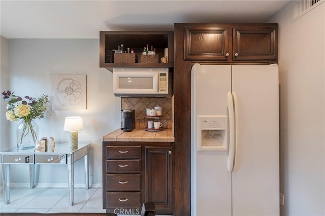 bar featuring white appliances, light tile patterned floors, visible vents, and decorative backsplash