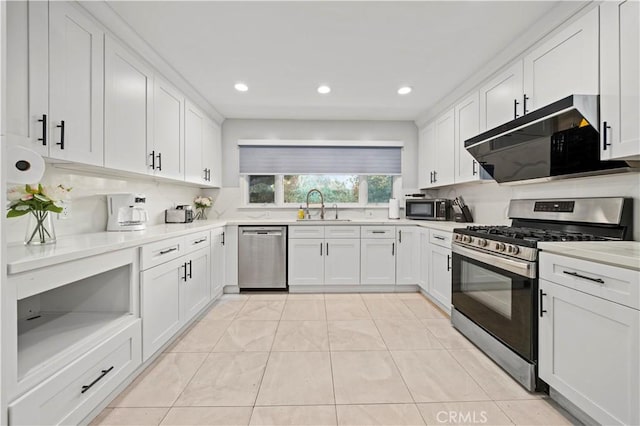 kitchen with appliances with stainless steel finishes, white cabinets, a sink, and light countertops