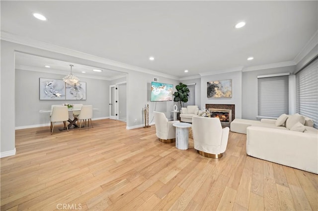 living room with baseboards, light wood-type flooring, a glass covered fireplace, and recessed lighting