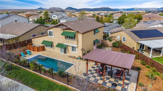 exterior space featuring a patio area, a residential view, a mountain view, and a fenced backyard