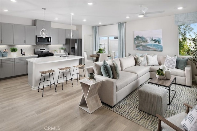 living area with recessed lighting, plenty of natural light, and light wood-style flooring