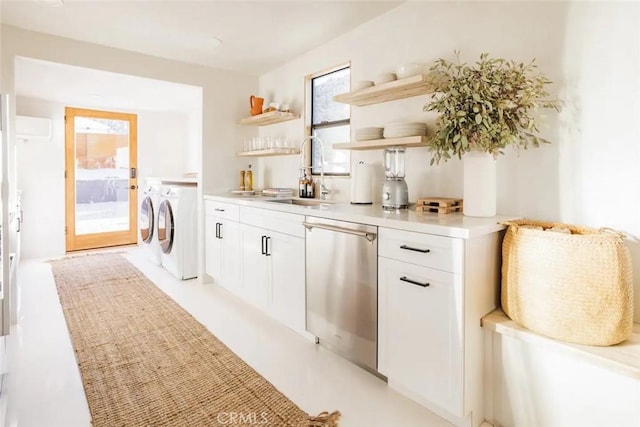 interior space with a sink, washer and clothes dryer, and stainless steel dishwasher