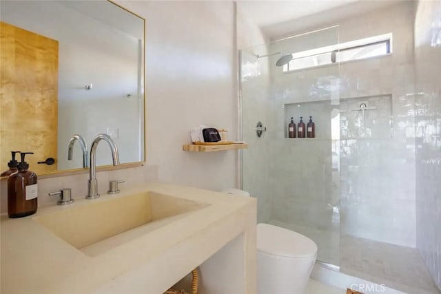 bathroom featuring toilet, a walk in shower, and vanity