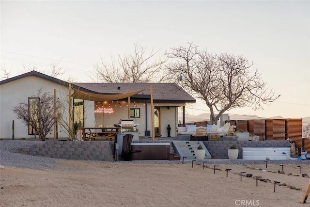 back of house at dusk with stucco siding