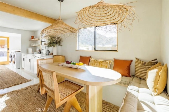 dining area with beamed ceiling and separate washer and dryer