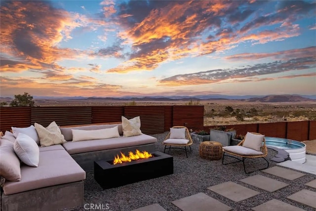 view of patio featuring an outdoor living space with a fire pit, fence, and a mountain view