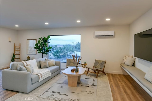 living area with recessed lighting, a wall mounted air conditioner, baseboards, and wood finished floors