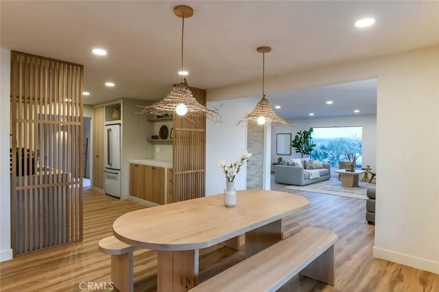 dining room featuring light wood finished floors, baseboards, and recessed lighting