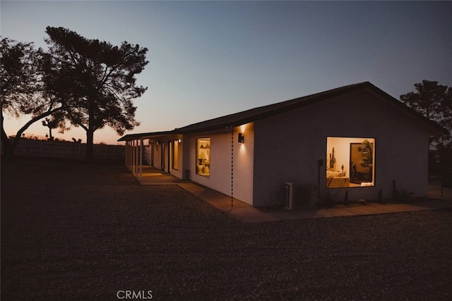 view of side of property with central air condition unit and stucco siding