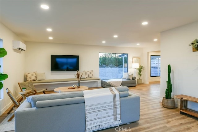 living room featuring baseboards, a wall mounted AC, wood finished floors, and recessed lighting