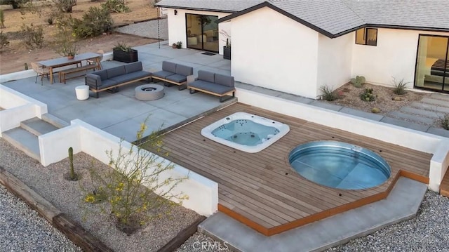 view of swimming pool with an outdoor living space with a fire pit, hot tub deck surround, and a patio