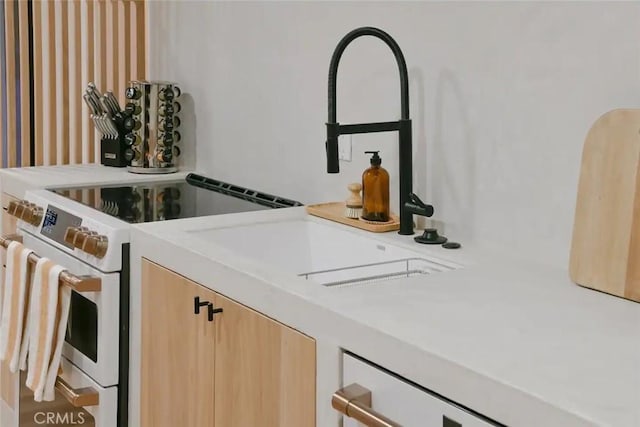 interior space with light countertops, electric range, and light brown cabinetry