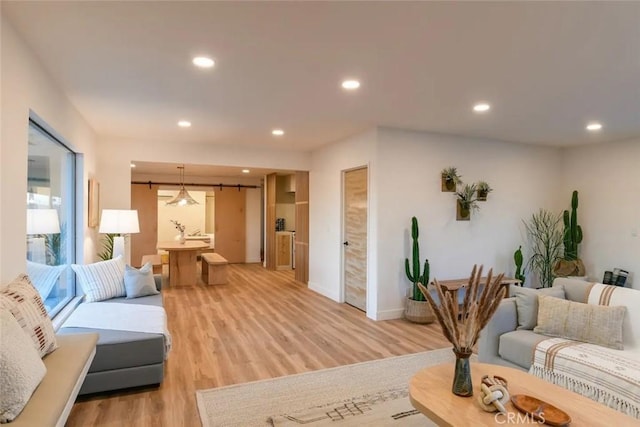 living area with light wood-type flooring, baseboards, and recessed lighting