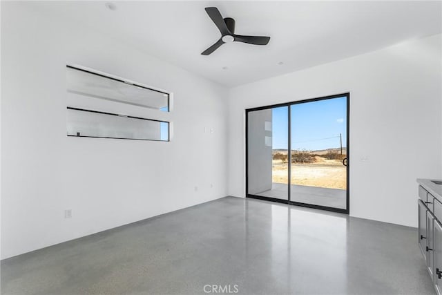 unfurnished room with concrete flooring and ceiling fan