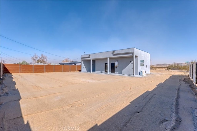 back of house featuring fence and stucco siding