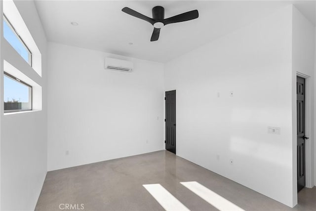 empty room with concrete flooring, an AC wall unit, and a ceiling fan