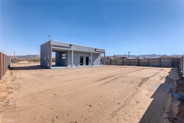 rear view of house with a fenced backyard and stucco siding