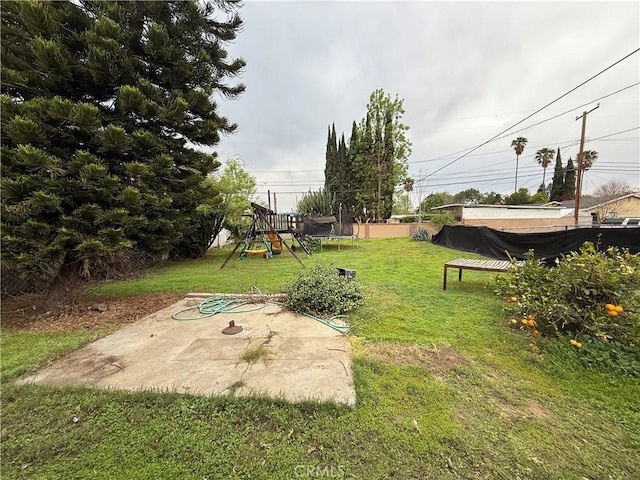 view of yard featuring a trampoline and a playground