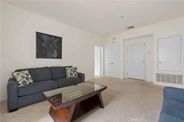 living room featuring visible vents, light colored carpet, and baseboards