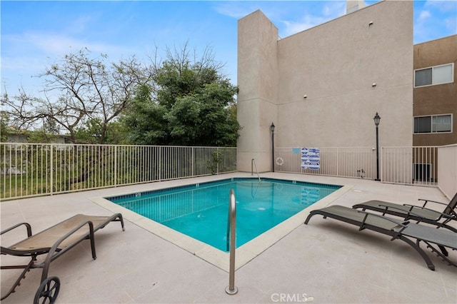 pool featuring fence and a patio area