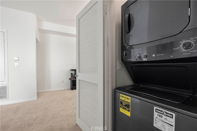 laundry room with visible vents, baseboards, light carpet, laundry area, and stacked washer and clothes dryer