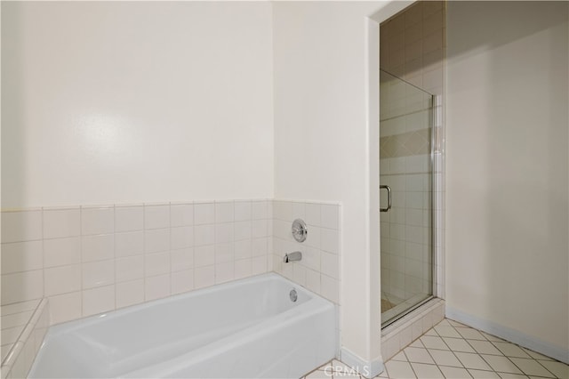 bathroom with tile patterned floors, baseboards, a garden tub, and a shower stall