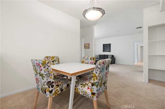 dining space with visible vents, baseboards, and light carpet