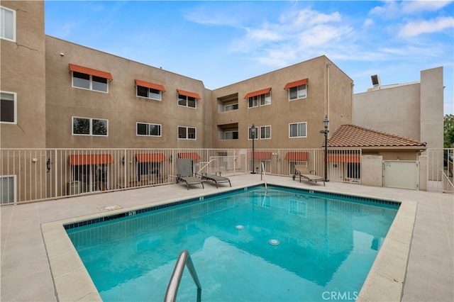 view of swimming pool with a patio area, a gate, and fence