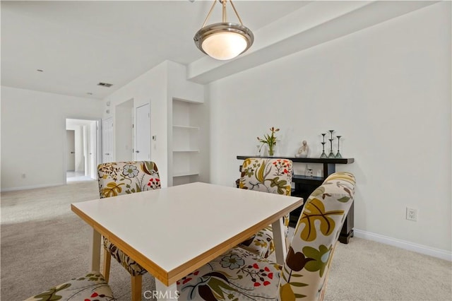 dining room with visible vents, light colored carpet, and baseboards