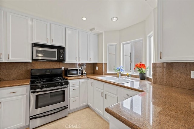 kitchen featuring a sink, tasteful backsplash, appliances with stainless steel finishes, and white cabinets