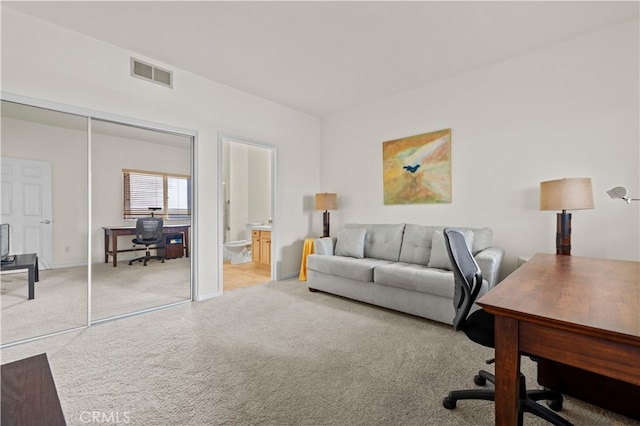 office space with light carpet, visible vents, and baseboards