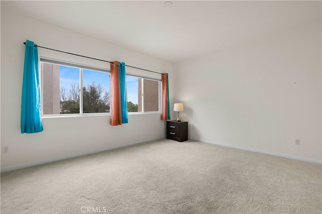 empty room with light colored carpet and baseboards