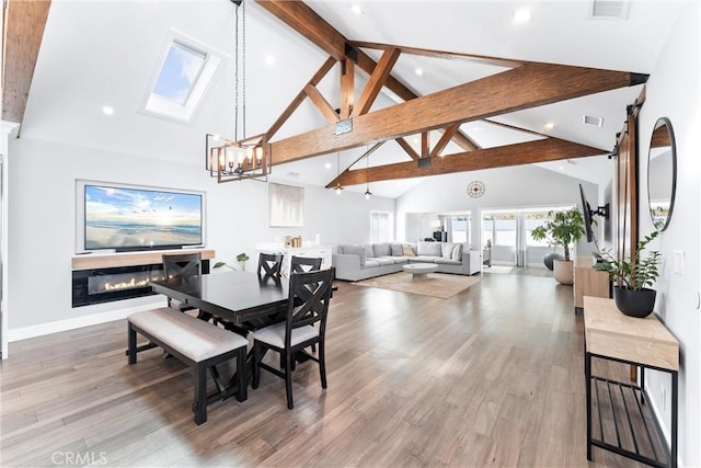 dining area with an inviting chandelier, visible vents, wood finished floors, and beamed ceiling