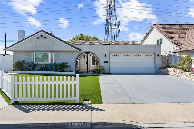 view of front of home featuring an attached garage, a gate, fence, and stucco siding