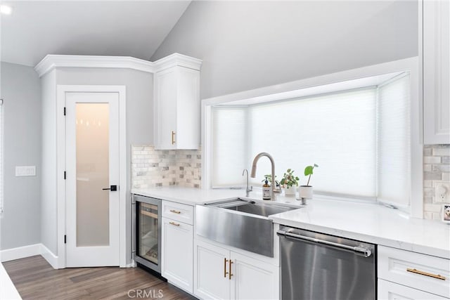 kitchen featuring beverage cooler, dishwasher, light countertops, white cabinetry, and a sink