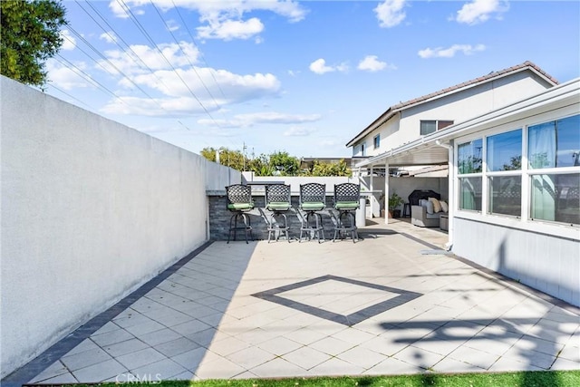 view of patio with a fenced backyard and outdoor dry bar