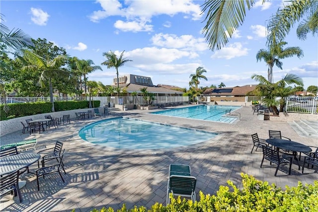 pool with a patio area and fence