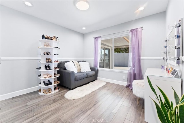 living area featuring washer / dryer, recessed lighting, baseboards, and wood finished floors