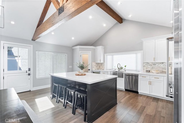 kitchen with light countertops, white cabinets, dishwasher, and wood finished floors