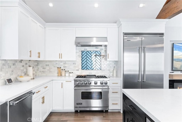 kitchen with white cabinetry, ventilation hood, premium appliances, and light countertops