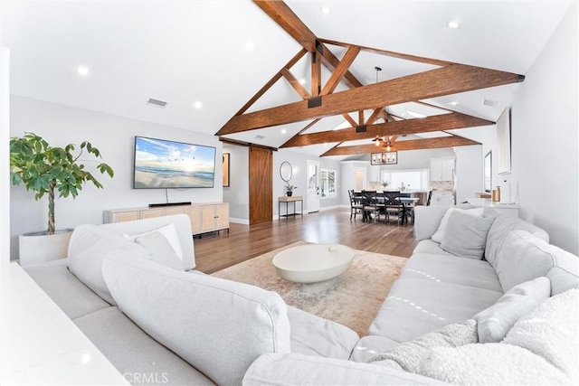 living room featuring high vaulted ceiling, beam ceiling, visible vents, and wood finished floors