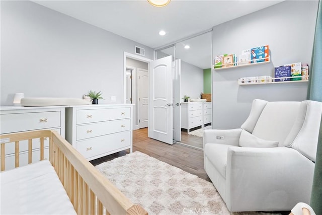 bedroom featuring wood finished floors, visible vents, and recessed lighting