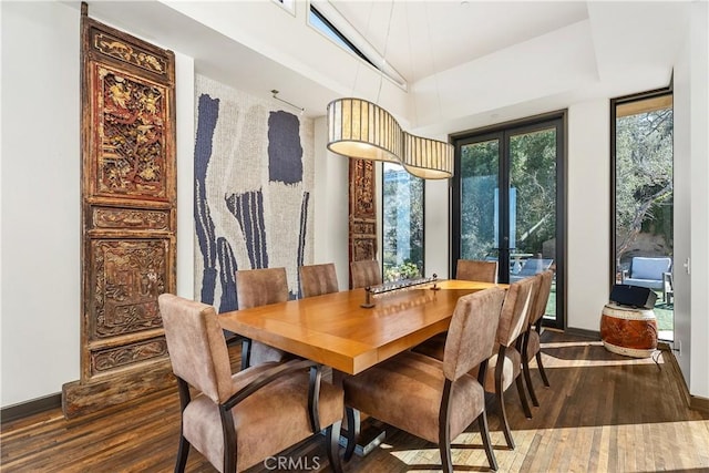 dining area featuring vaulted ceiling, wood finished floors, baseboards, and french doors