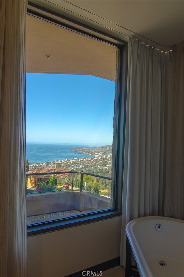 full bath featuring a soaking tub and a water view