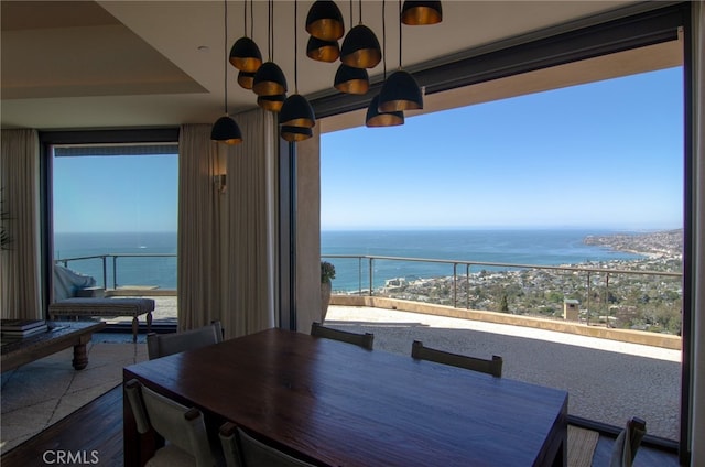 dining room with dark wood-style floors and a water view