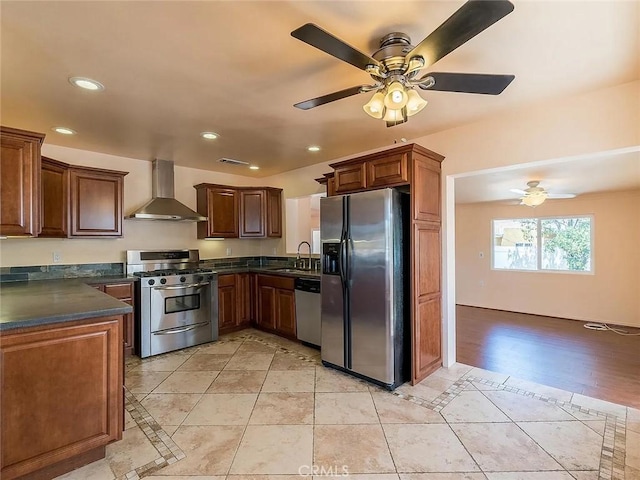 kitchen featuring dark countertops, wall chimney exhaust hood, stainless steel appliances, a sink, and recessed lighting